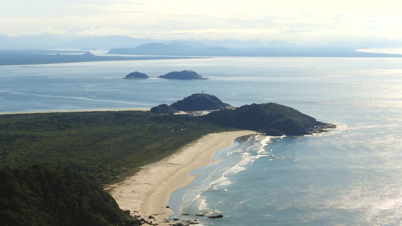 Aerial view of Ilha do Mel island long beach side stretching between forested hills and smaller islands, Paraná, Brazil
