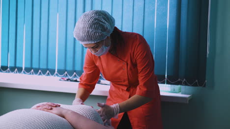 cosmetologist does massage of large woman face in clinic