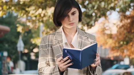 female entrepreneur writing in notepad while resting outdoor.