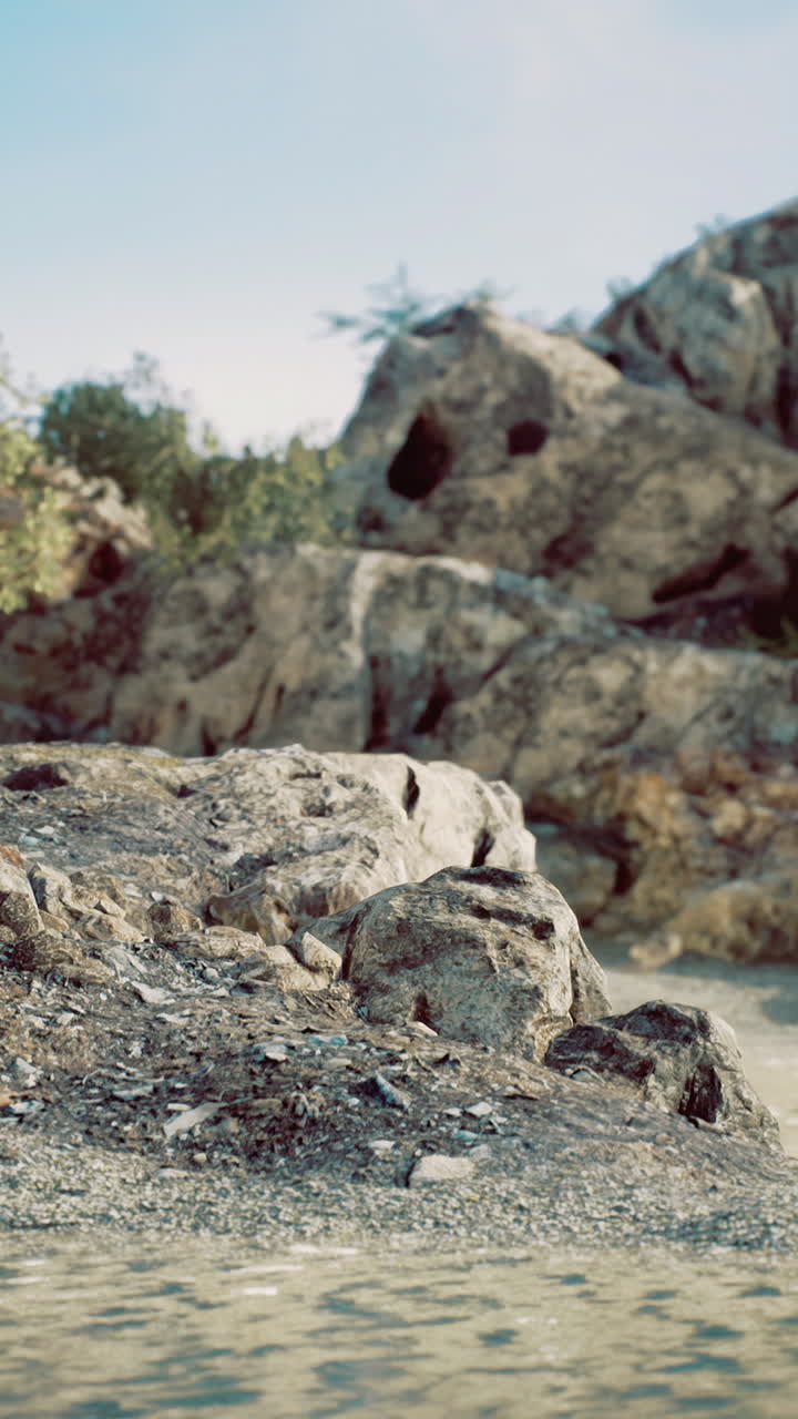 Paesaggio costiero roccioso con massi erosi e spiaggia sabbiosa