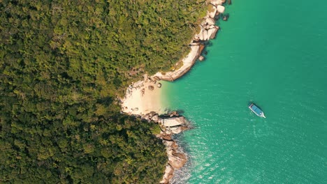 Aerial-top-down-view-of-brazilian-secret-paradise-beach-with-turquoise-color,-wooden-anchored-boat-near-dense-amazon-rainforest