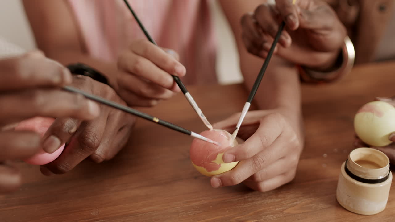 personas irreconocibles pintando huevos de pascua