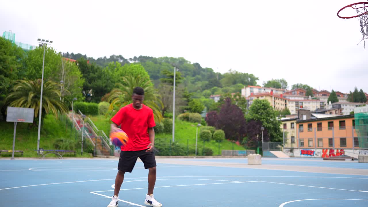 Man playing basketball on an outdoor court