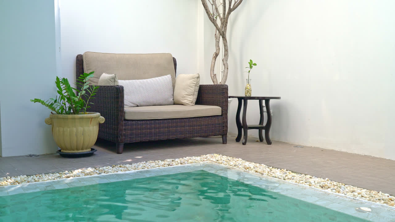 Cómoda almohada decorar en el sofá alrededor de la piscina