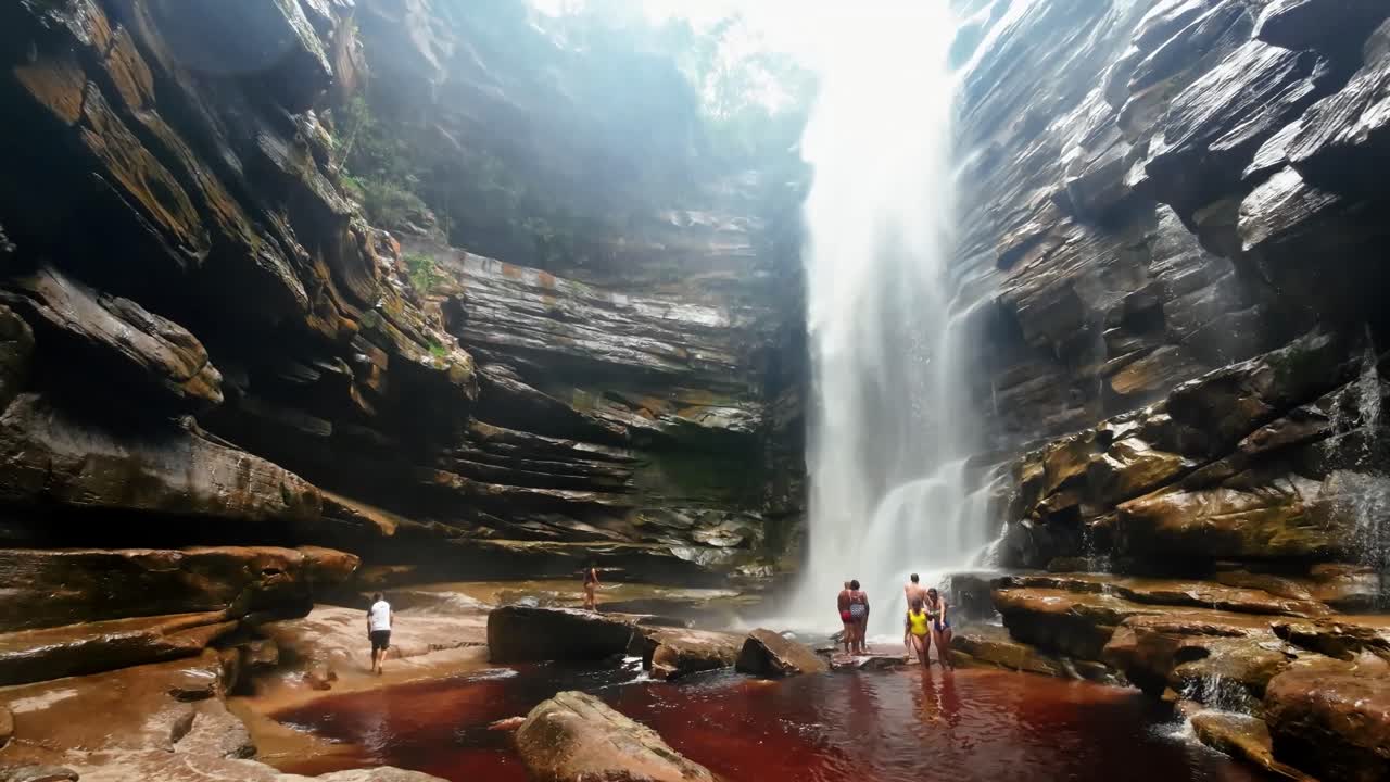 cámara de acción en cámara lenta inclinada desde la base de la cascada de mosquitos mirando hacia arriba rodeada de plantas y acantilados y un río en el parque nacional chapada diamantina en el noreste de brasil