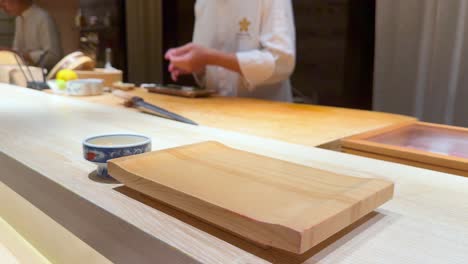 el chef prepara hábilmente sushi en un mostrador