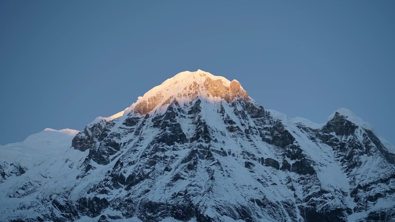 cresta montañosa nevada con cielo azul en nepal, montañas cubiertas de nieve paisaje en la nieve con cara de montaña empinada en la primera luz al amanecer con luz en la cima de la montaña en el himalaya montañas en nepal