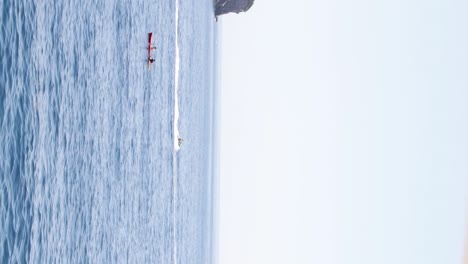 Jet-ski-racing-past-a-kayak-in-the-crystal-clear-the-Adriatic-Sea-in-Dubrovnik,-Croatia