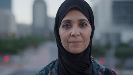 portrait middle aged muslim woman turns head smiling confident enjoying successful urban lifestyle independent senior female wearing hijab headscarf in city at sunset slow motion