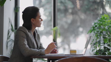 arabian hispanic woman working financial paperwork seated at workplace using laptop looks concentrated while makes task prepare check report having fruitful workday. student learning process concept