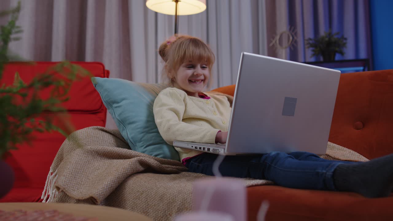 niña pequeña de escuela que usa una computadora portátil aprende a leer lecciones de educación en línea sola en casa