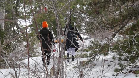 escena de estilos de vida mientras dos amigos caminan por un bosque de invierno con una botella de vino