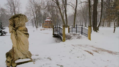 a man is strolling in a snowy park during a heavy snow fall