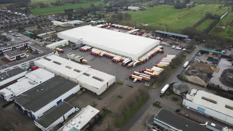 Aerial-of-distant-transportation-company-with-a-lot-of-trucks-parked-on-terrain