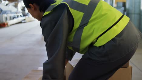 female worker suffering from back pain while holding heavy box 4k