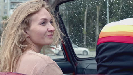 woman in a vintage car on a rainy day