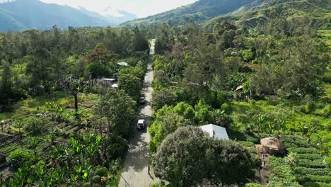 vehículos que circulan por una carretera sin asfaltar a través de aldeas remotas en las tierras altas de nueva guinea.