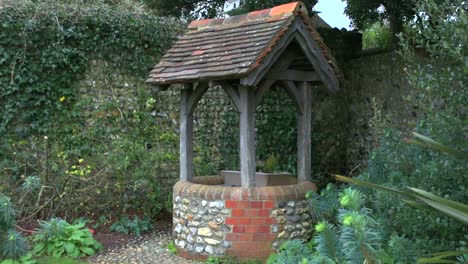 Left-tracking-shot-of-a-classic-old-village-well-on-a-windy-day,-at-Rottingdean-in-East-Sussex,-England