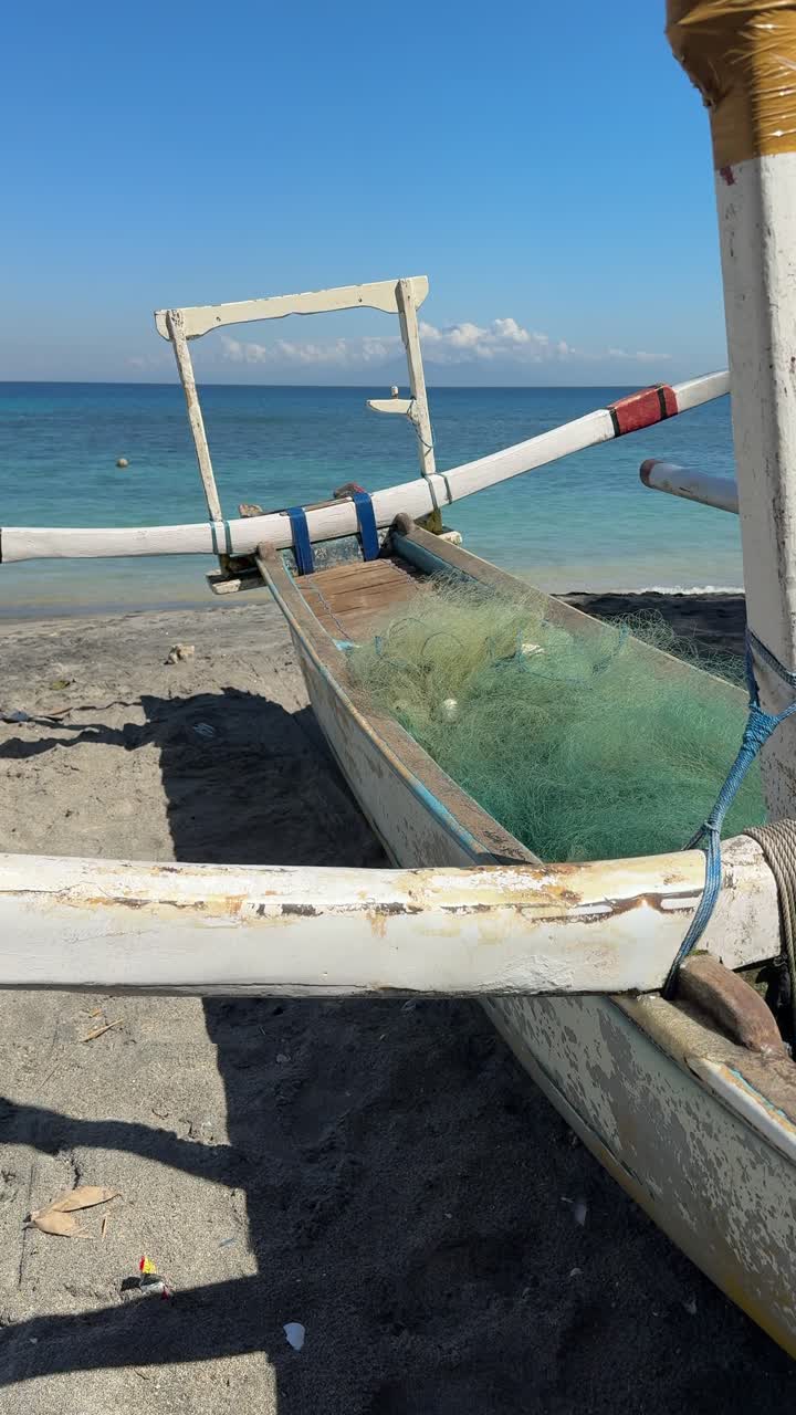 Barca da pesca tradizionale su una spiaggia tropicale con oceano blu.