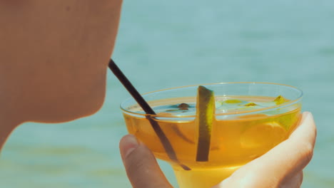 mujer bebiendo un cóctel refrescante con una pajita
