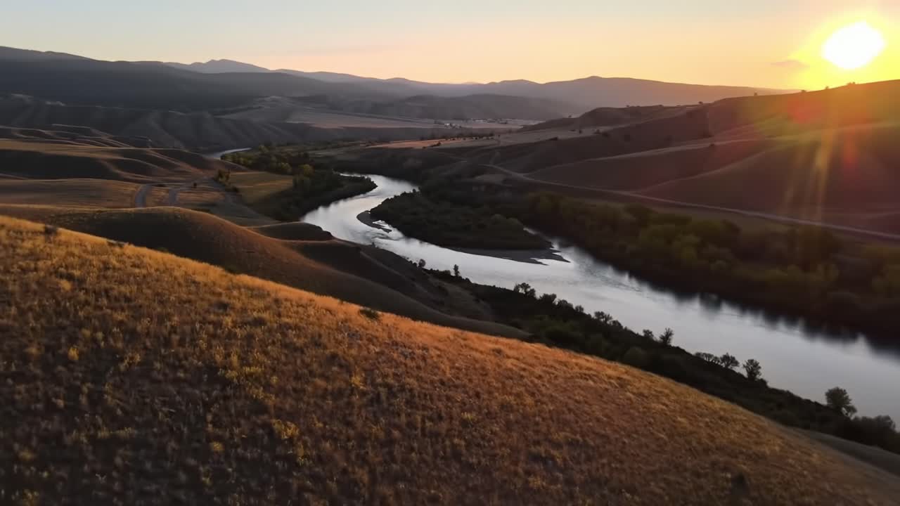 Tramonto sereno su dolci colline: una vista panoramica di un fiume tortuoso che riflette il bagliore dorato mentre il giorno si trasforma in notte in un paesaggio pacifico