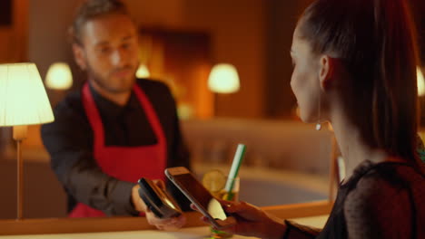 mujer comprando cócteles en un bar