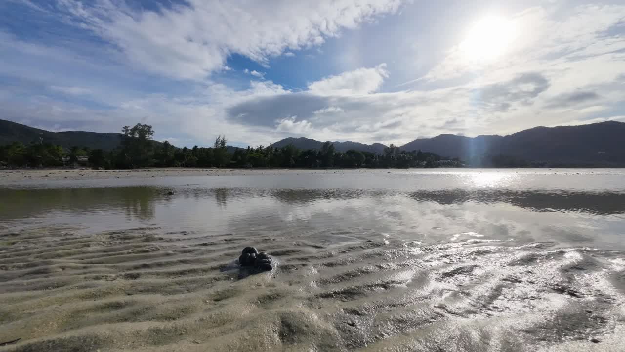 Time lapse footage of marine worms creating sand castings on a tropical beach in Koh Phangan Thailand with scenic mountains in the background during low tide
