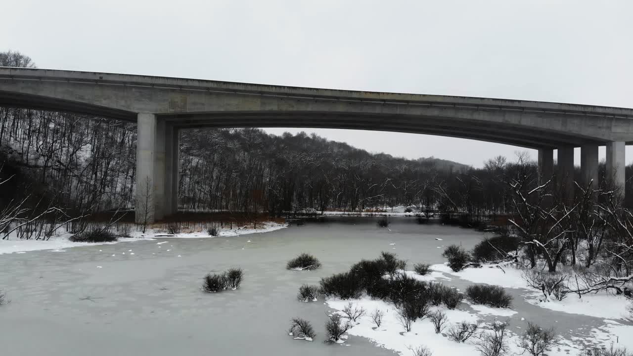 눈이 내리면서 미주리의 얼어붙은 호수 위에 있는 페이지 브리지의 천천히 상승하는 샷