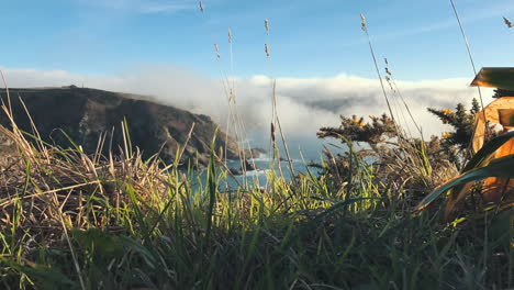 timelapse of low cloud approaching an island cliff and climbing over it