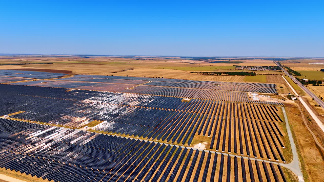 Solar panels blanket sunny fields. Solar panels stretch across the landscape under a clear blue sky, highlighting renewable energy in action