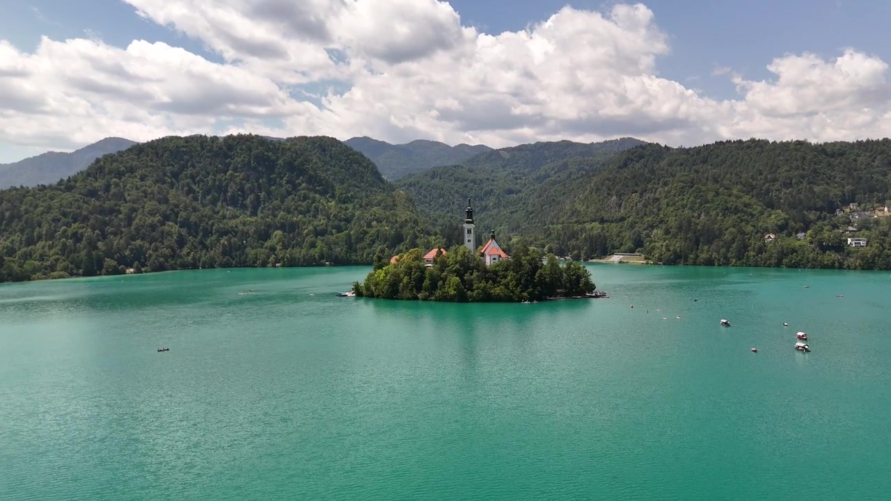 Drohnenansicht des Bleder Sees in Slowenien mit Insel und Bergen.