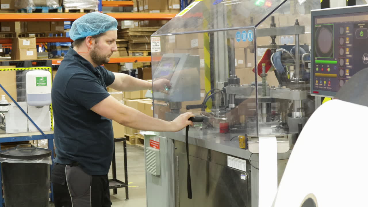 trabajador masculino que opera una prensa eléctrica, fabricación industrial