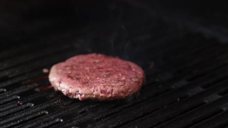 burger patty cooking on a hot grill