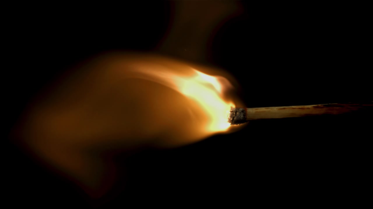 Matchstick Igniting and Burning in Slow Motion on Black Background