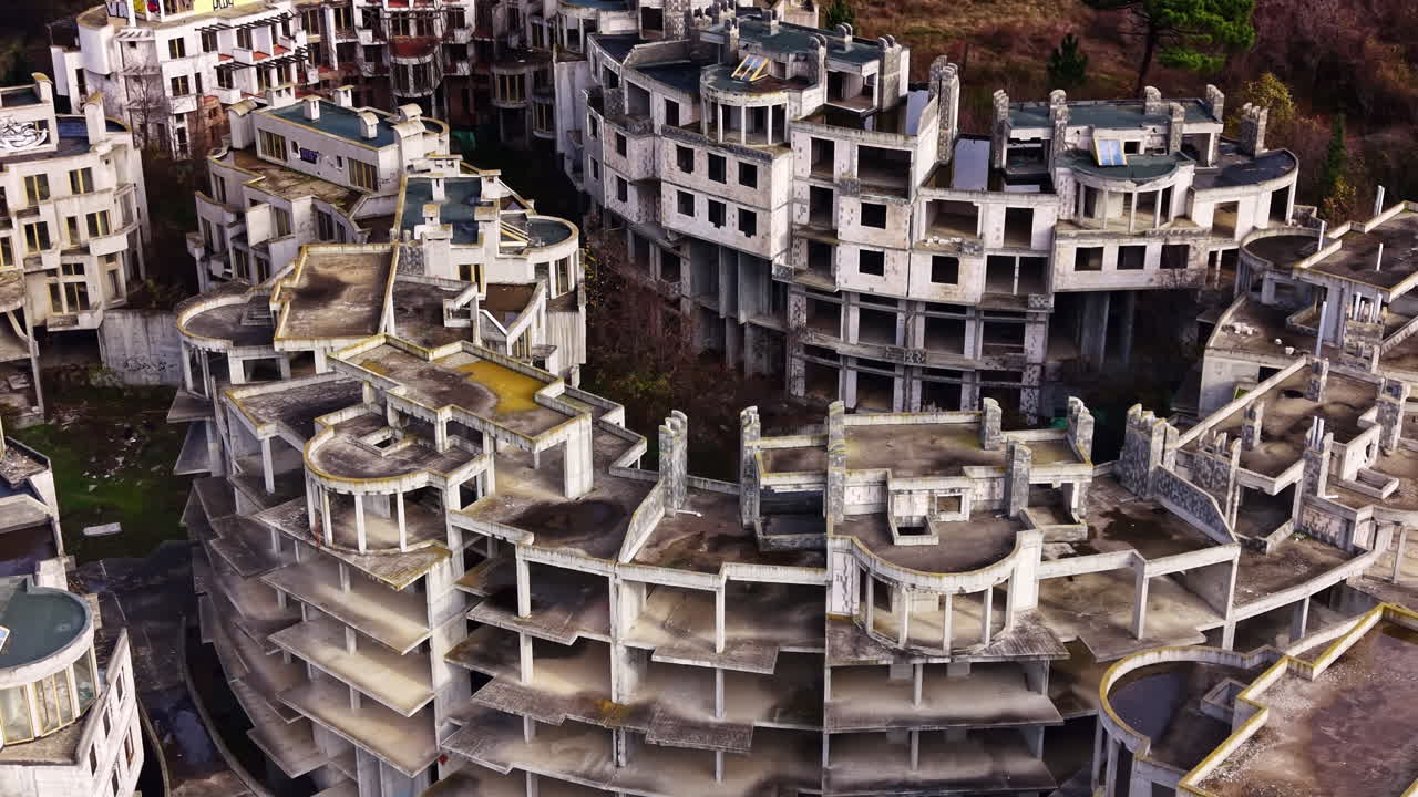 Abandoned architectural wonder reveals the passage of time in a forgotten construction site surrounded by nature's reclaiming touch