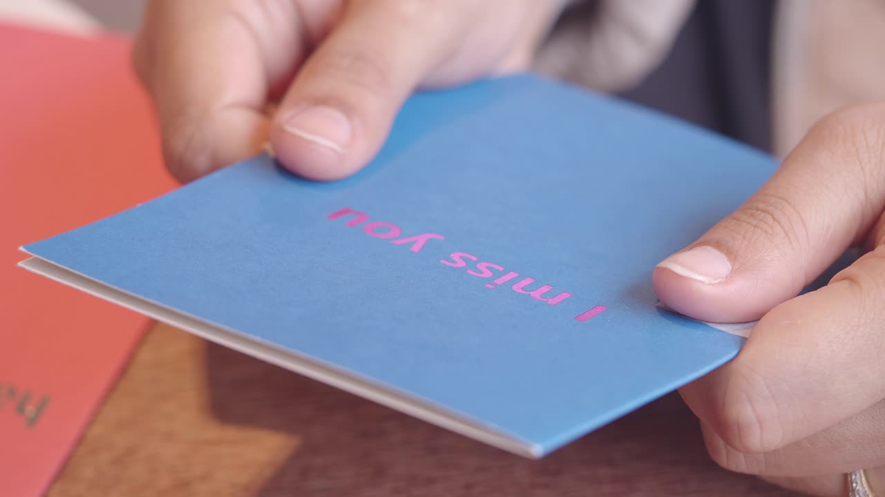 Person Holding a 'I Miss You' Card