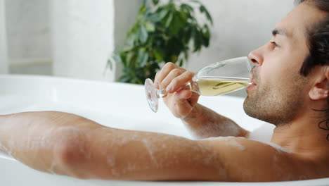 man enjoying champagne in a bath