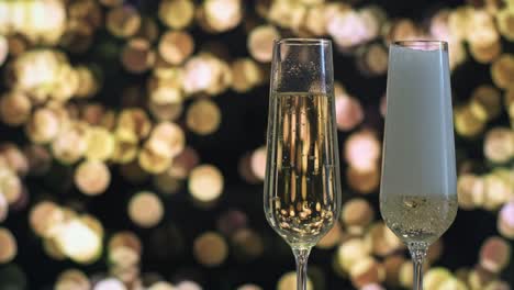 two champagne flutes, one being filled with sparkling wine, set against a backdrop of golden bokeh lights. the scene exudes celebration and elegance, perfect for festive occasions or new year's eve.