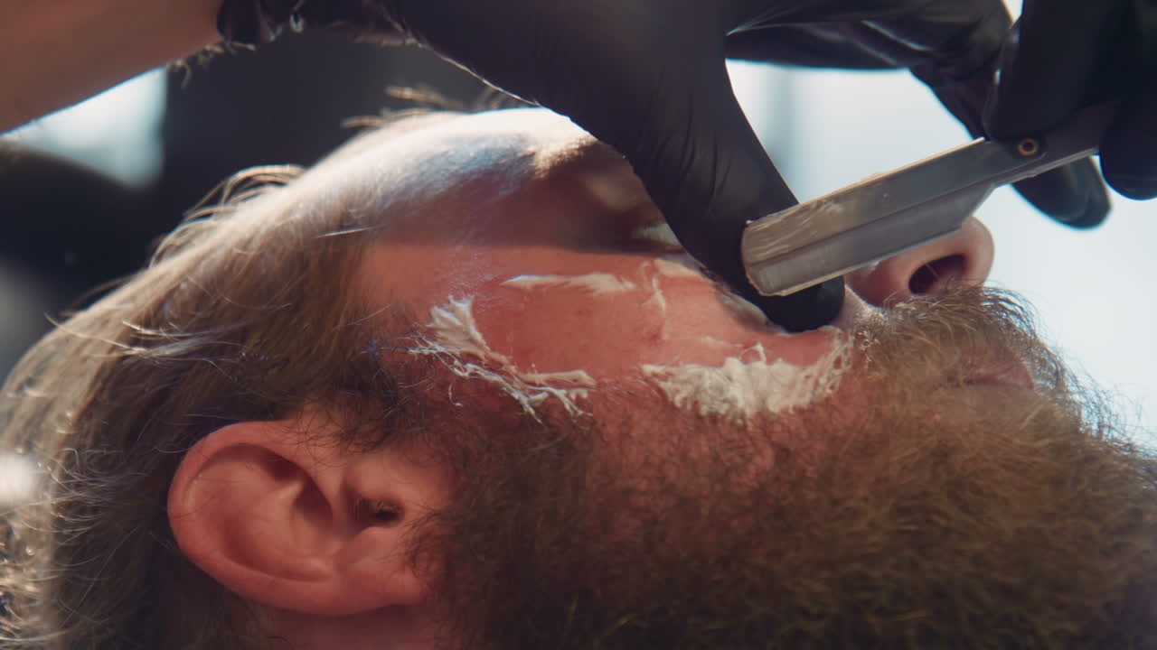 un hombre se afeita en una barbería.