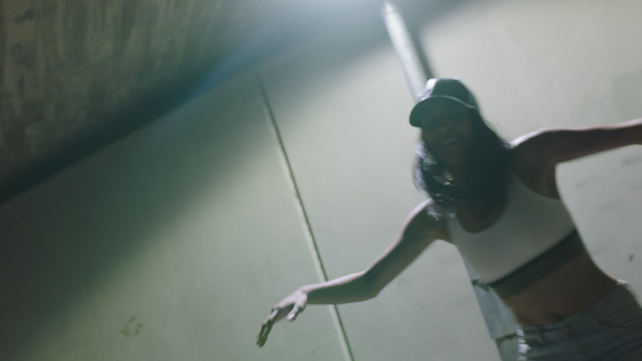 mujer bailarina joven bailarina de break mujer practicando movimientos de danza freestyle moderna bajo la luz de la calle en la ciudad por la noche