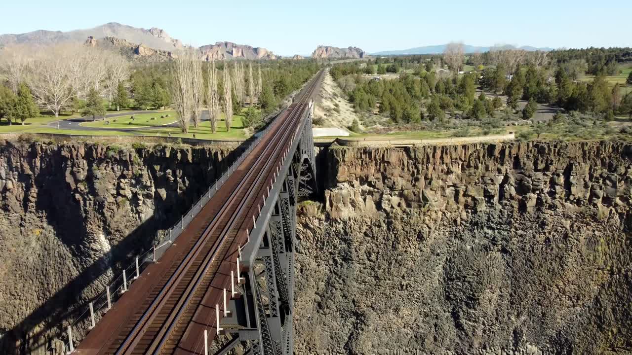 US, Oregon, Redmond, Crooked River High Bridge, 2025-04-12 - Drone view of the steel truss railroad bridge over the Crooked River at Highway 26 in spring with Smith Rock in the distance.