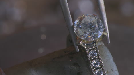 una gema que se coloca suavemente en un anillo con una herramienta