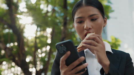 business woman eating lunch and using phone
