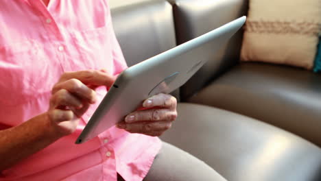 close up view of retired woman playing with tablet computer