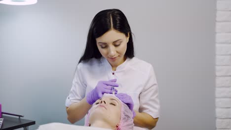 a woman on the procedure of injections in a cosmetology clinic. preventing wrinkles.