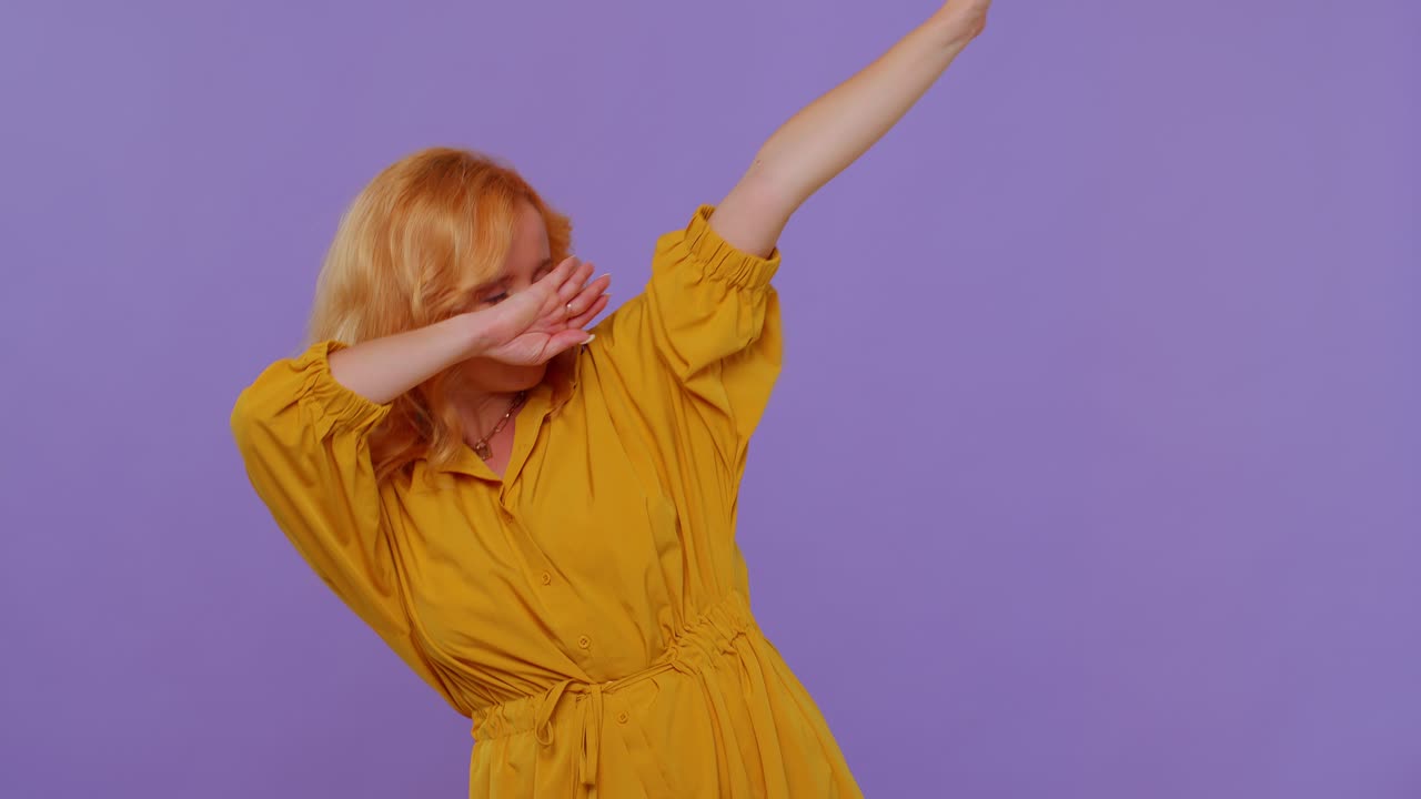 Trendy cheerful girl dancing and moving to rhythm, dabbing raising hands, making dubdance gesture