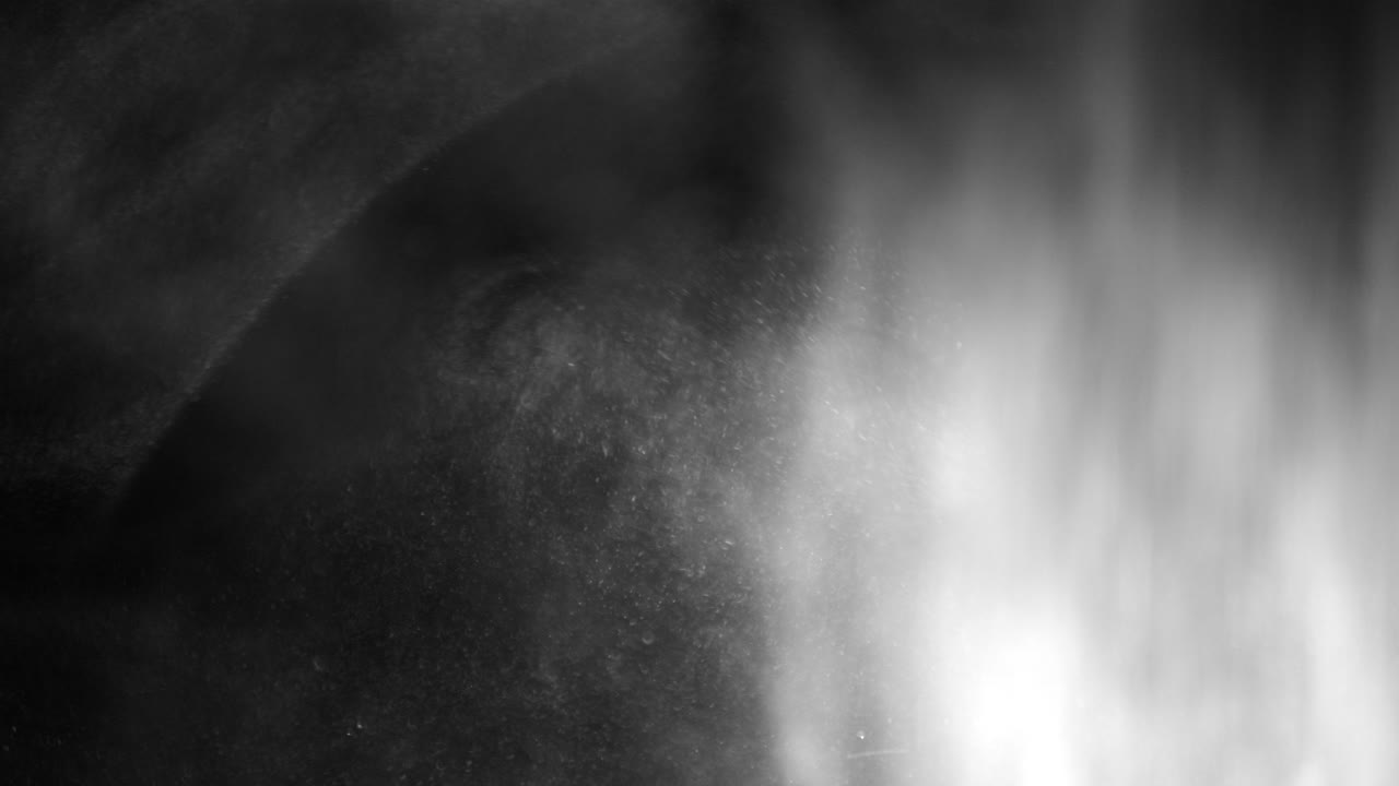 폭설처럼 검은 배경에 떠다니고 떨어지는 클로즈업 먼지