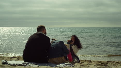 la familia disfruta de fotos en la playa de vacaciones. la gente posa con la cámara junto a la costa de las olas del mar.