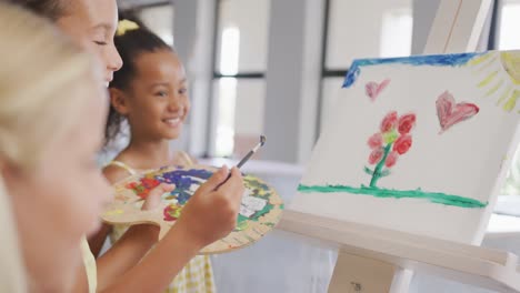 Video-of-happy-diverse-girls-painting-during-art-lessons-at-school