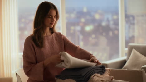 woman folding clothes with city view